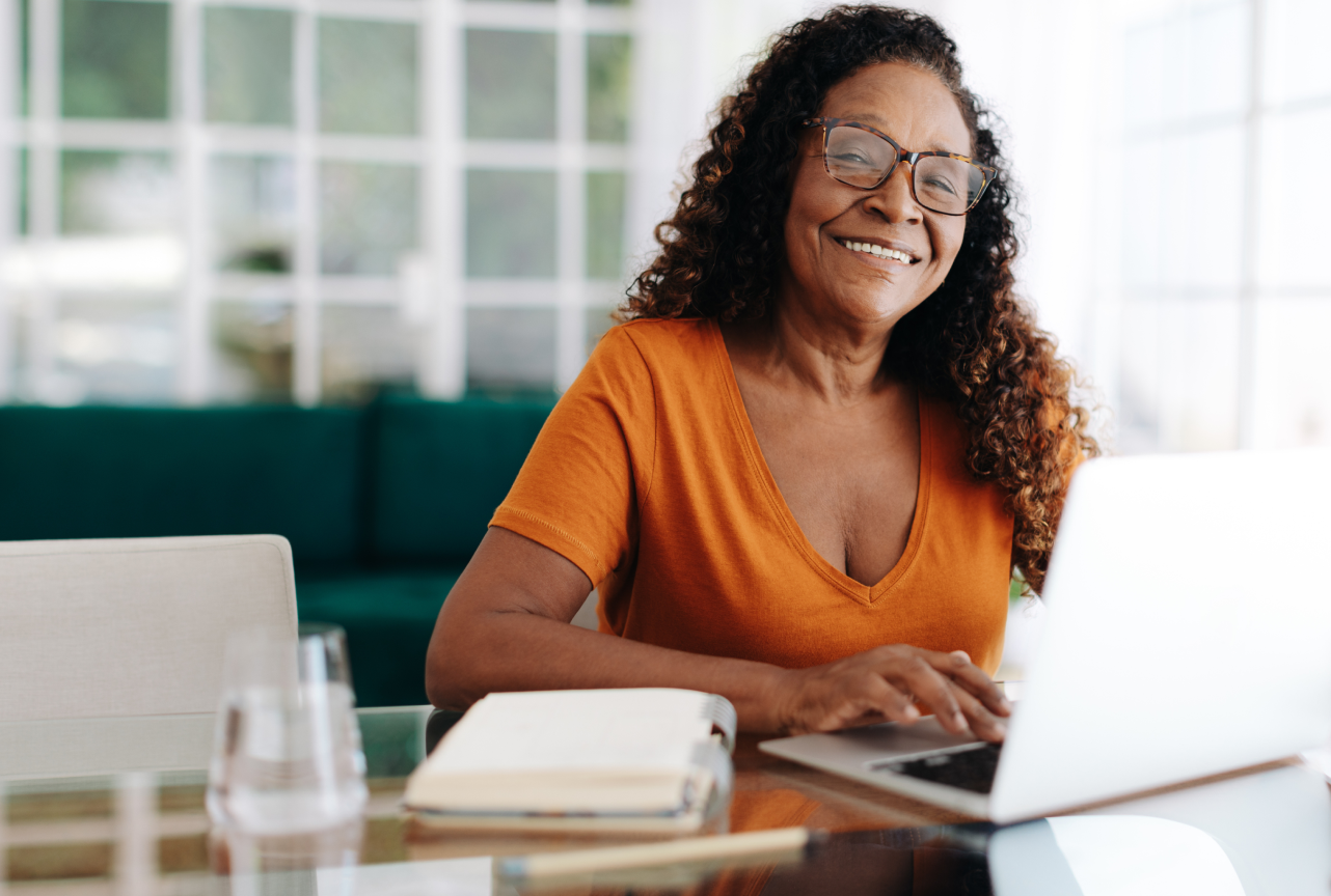 Woman smiling while working on laptop